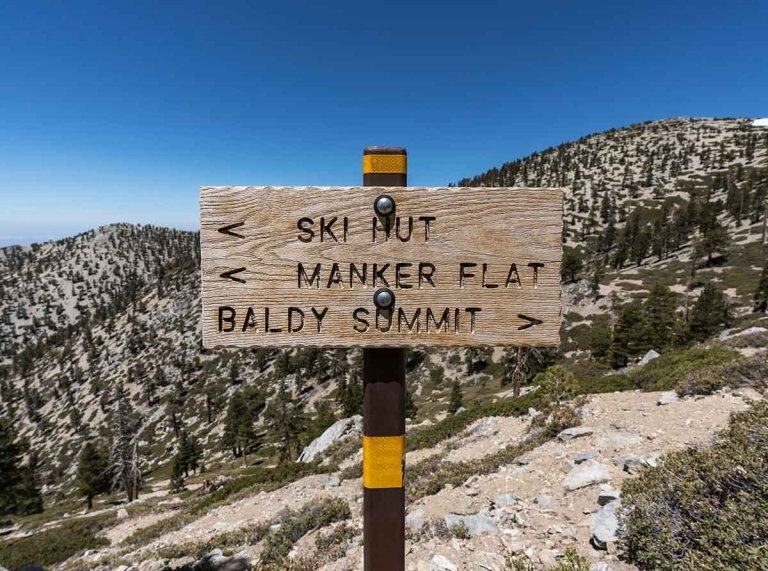 wood hiking trail sign on mt baldy pointing to the ski hut, manker flat, and baldy summit