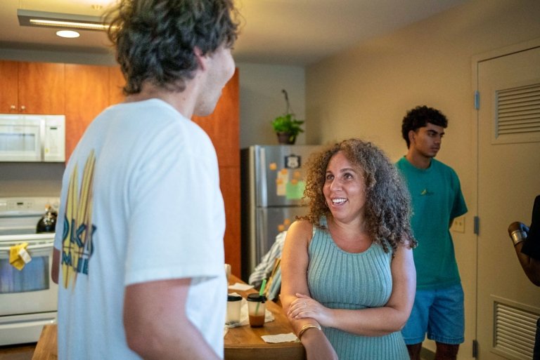 Fely Catan talks to a student in the kitchen of her faculty apartment.
