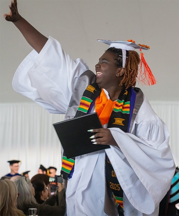 A Pitzer student waves during commencement