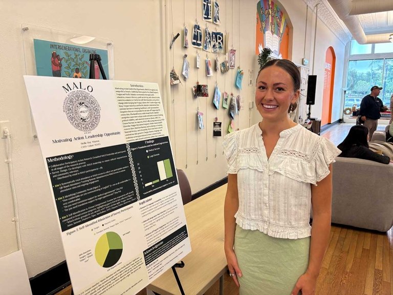 Stella Guy Warren poses in front of her research poster at CASA