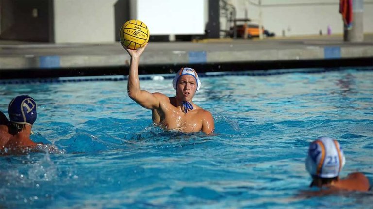 jaden winters prepares to throw the ball during a water polo game