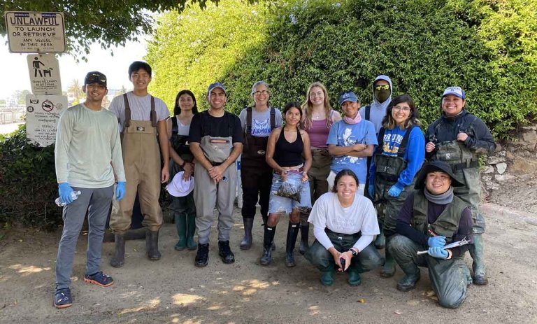 Professor Sarah Gilman and her research group pose as a group out in the field