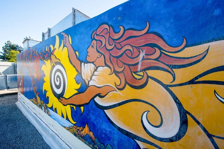 mural detail of a woman with long brown hair flying through a blue expanse