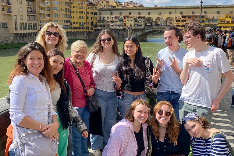 a group of students pose near a river