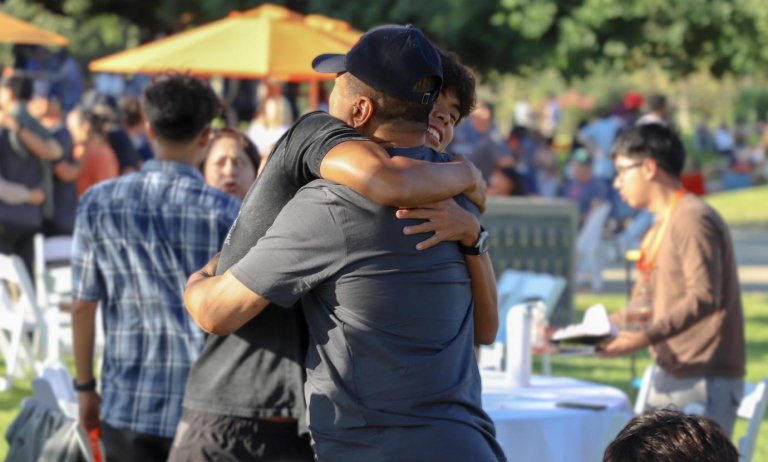 a student and father hug