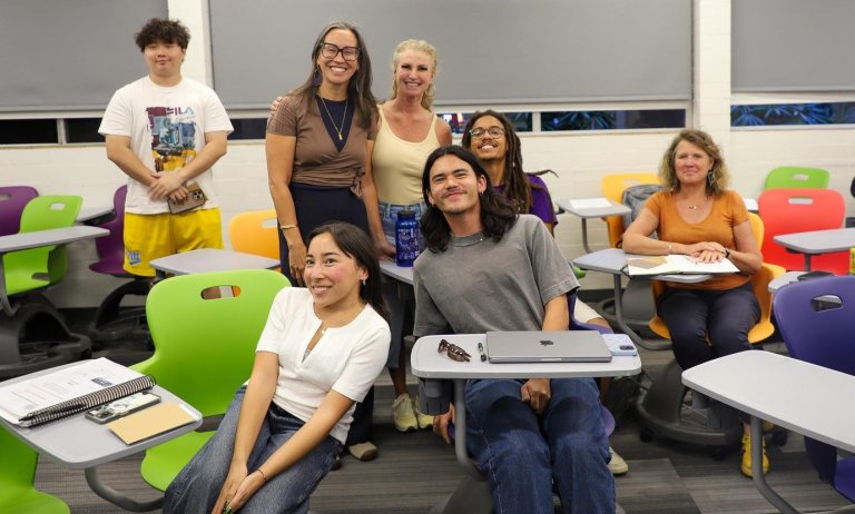 parents and students pose with Professor Junisbai at a lecture during family weekend