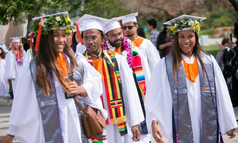 graduates in line wear a variety of different stoles at commencement
