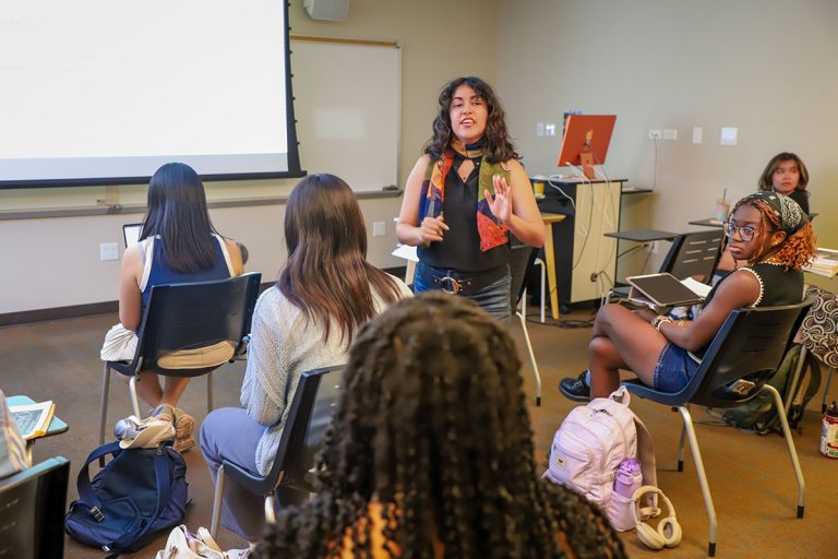 andrea acosta teaching a class in a room full of students