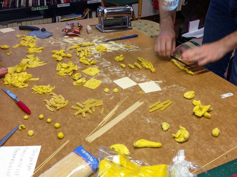 an array of pasta shapes laid out on a table during a pasta-making workshop