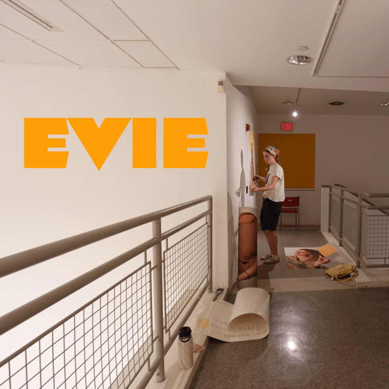 Female artist installs artwork on wall