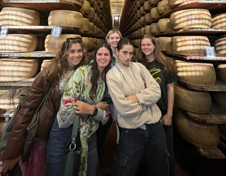 Students in front of giant cheese wheels 