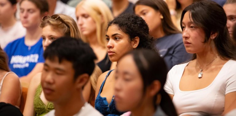 a group of students intently watching a speech