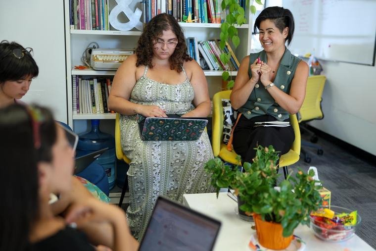 a group of students with an instructor sitting in a circle talking