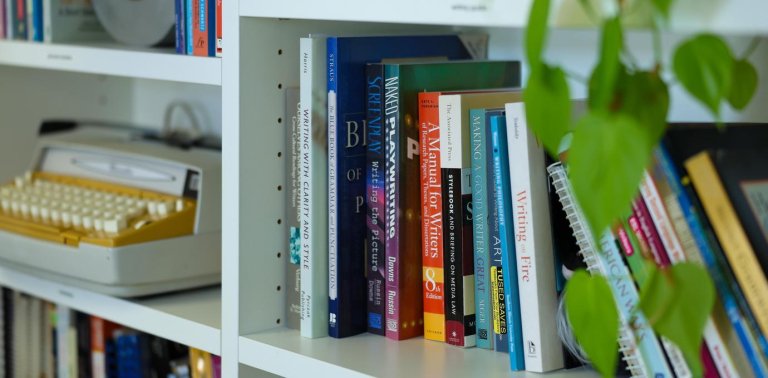 bookcase featuring a typewriter and plants