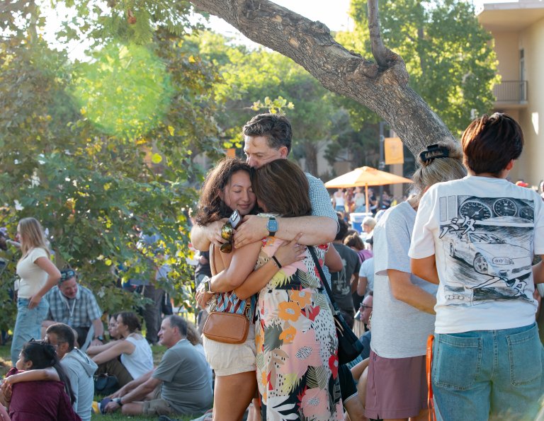 a family hugging, surrounded by people on move in day