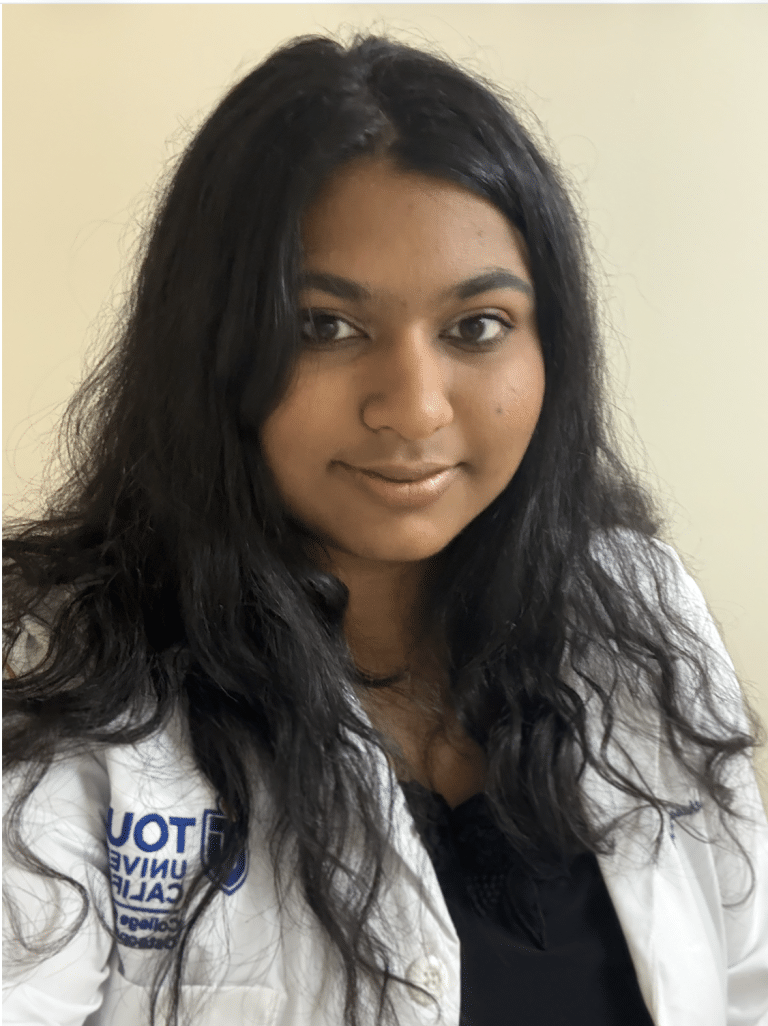 A selfie of Arpitha wearing a white lab coat