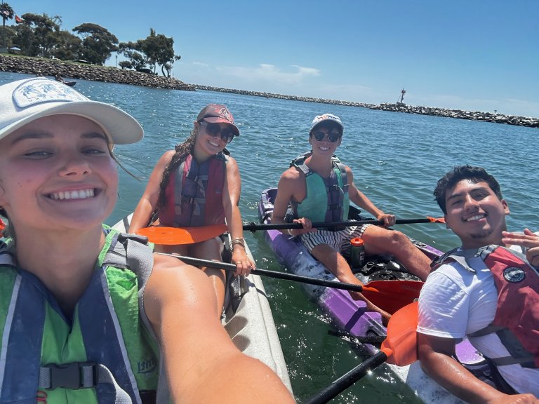 students taking a selfie on a kayak in the water