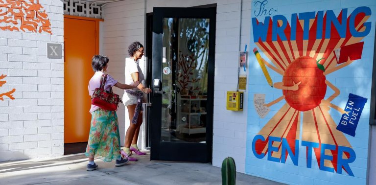 two students walk into the front door of the writing center