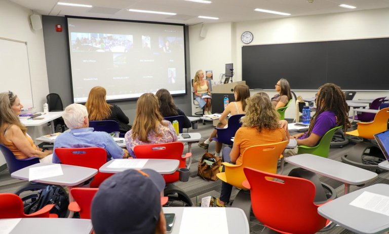 parents and students sit in on a class during family weekend