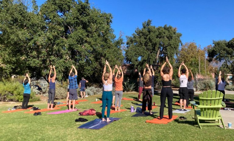 students and family do yoga on the mounds