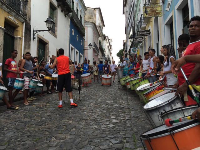 Drummers line a cobblestone street in Brazil.