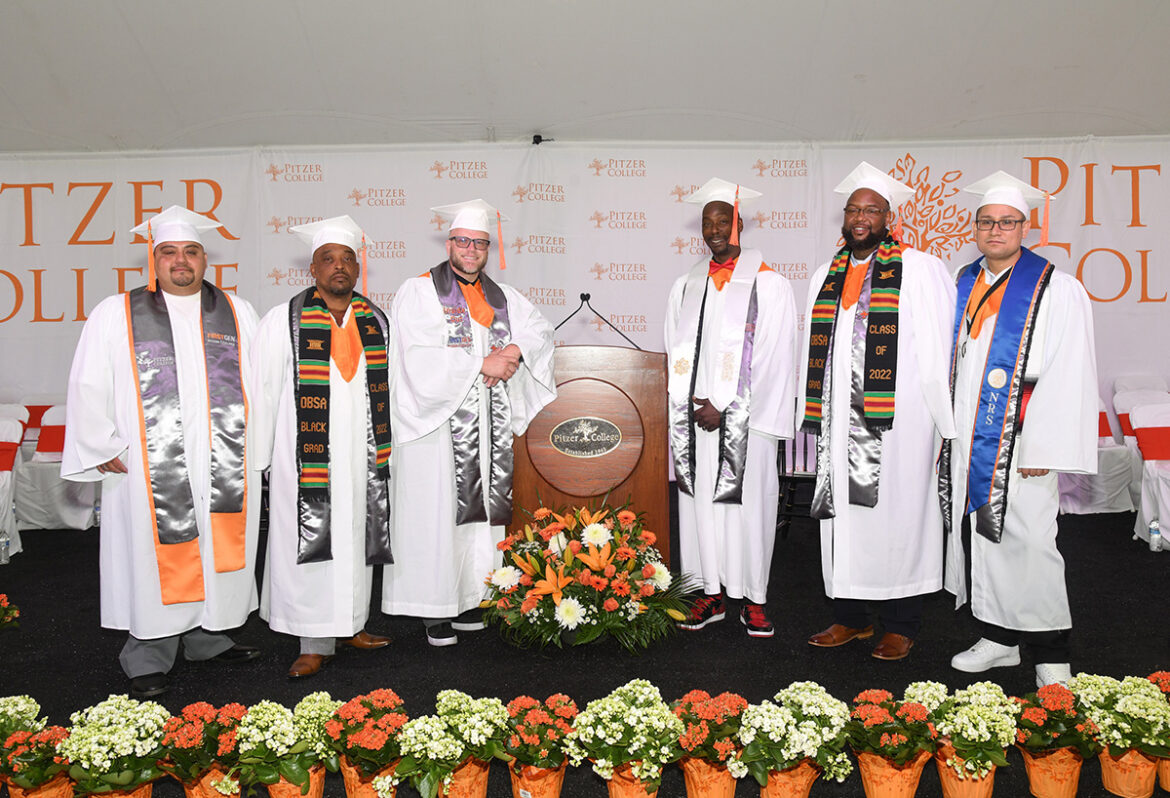 Four Inside out graduates pose at a podium