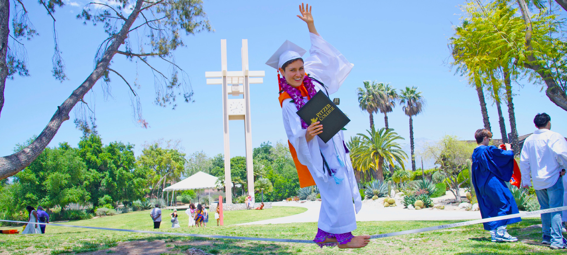 Pitzer graduate balances on a tightrope while holding diploma