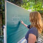 student solving math problem on a blackboard